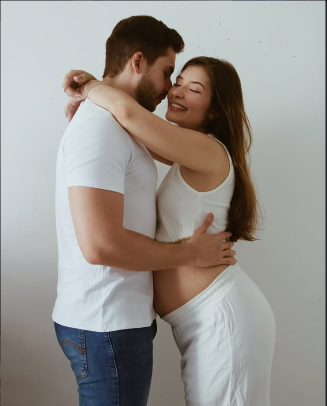 Casal em ensaio de gestante, abraçados