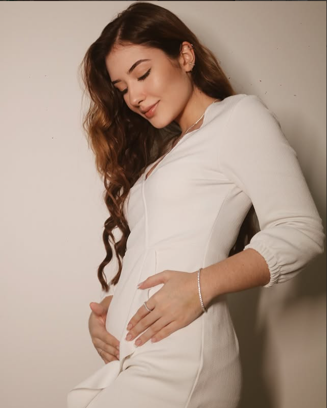 Gestante segurando a barriga em ensaio fotográfico