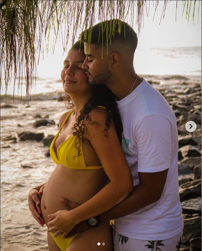 Casal na praia durante ensaio de gestante